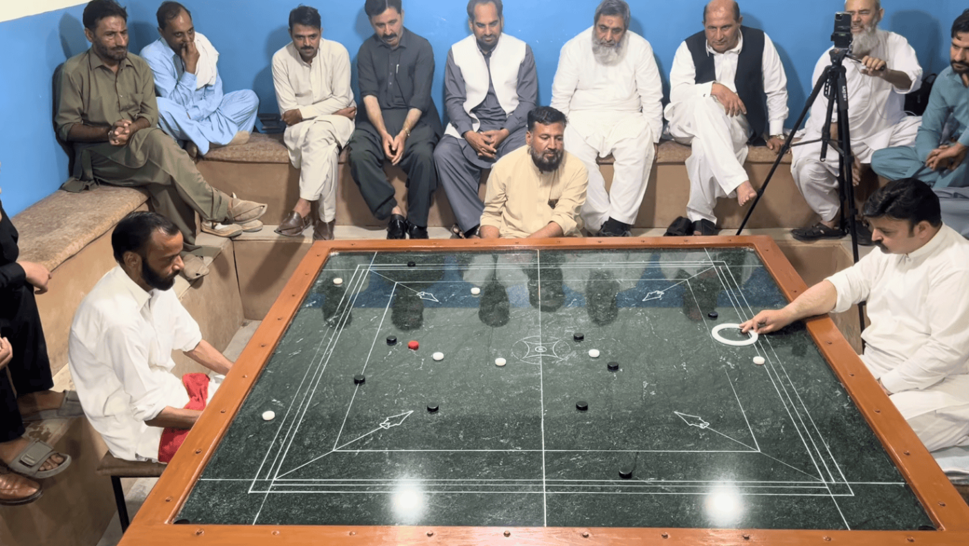 A Pakistani carrom match played on a large polished marble board.